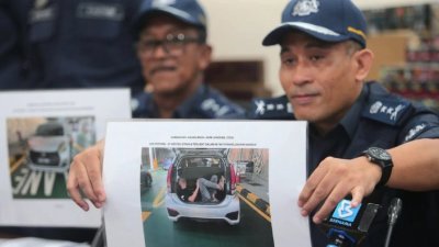 阿米努展示新加坡男子躲后车厢偷渡来我国的照片。（图取自大都会日报）