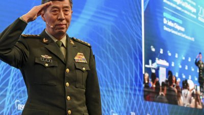 去年6月4日，时任中国国防部长李尚福在新加坡香格里拉对话会发表演说前在台上敬礼。（法新社档案照）