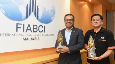 菲道斯慕沙（左）和俞贵狮展示2023年马来西亚产业大奖的奖杯。