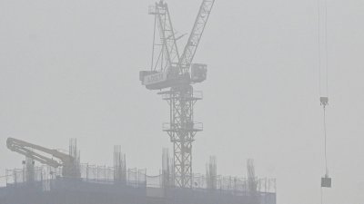 越南首都河内周二被污染雾霾笼罩，建筑工地上的一台起重机几乎看不见。（图取自法新社）