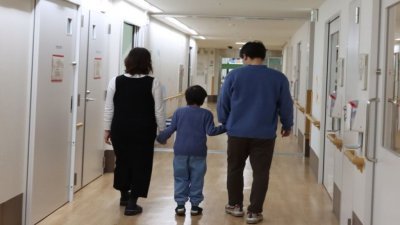 男童在3月1日牵著父母手步出医院。（图取自京都大学医院）