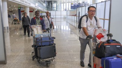 中国持续增加试行免签证的国家。图为免签入境的新加坡旅客抵达海南省海口市美兰国际机场。（图取自中新社）