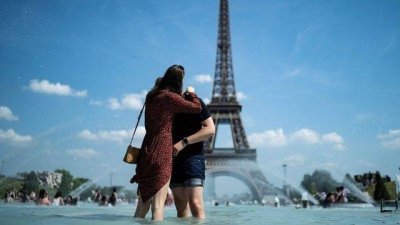 高温热浪席卷欧洲，巴黎埃菲尔铁塔前的喷泉大受人们的欢迎。（法新社档案照）