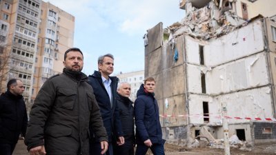 乌克兰总统泽连斯基（左2）和到访的希腊总理米佐塔基斯（左3）当地时间周三造访敖德萨，走在因无人机攻击而受损的住宅大楼前。（图取自乌克兰总统新闻服务/法新社）