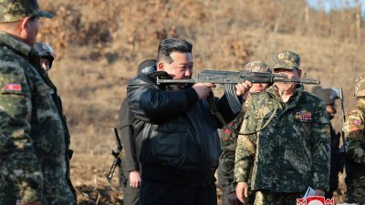 朝鲜最高领导人金正恩周三在西北地区的重要作战训练基地视察期间，在现场拿枪摆出射击姿势。（图取自朝中社/法新社）