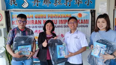 何子扬（右2）移交彭亨教育基金赞助B40群体学生的新书包及开学用品予金马仑丹那拉打华小吴校长（左2）。