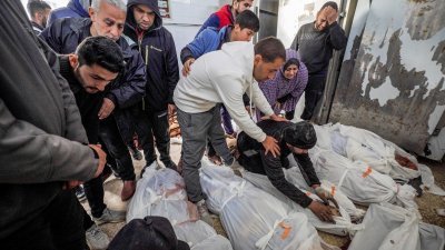 以色列和哈马斯之间的战斗仍在持续，巴勒斯坦人周三在代尔巴拉赫的阿克萨医院哀悼在以军轰炸加沙地带中部丧生的亲人。（图取自法新社）