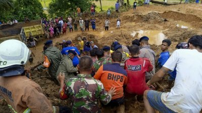 周五在西苏门答腊岛巴东帕里亚曼县的山体滑坡现场，救援人员在雨停后继续搜寻失踪者。（图取自法新社/BNPB）
