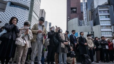 在东京银座购物区，人们在周一即311大地震13周年这天，为当年地震、海啸和核灾默哀一分钟，悼念罹难者。（图取自法新社）