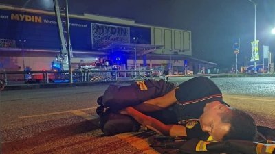 曼锐迈丁霸市于10日晚上发生火患，沙鲁迪一直留守现场，甚至在夜间就地睡下。（取自网络）