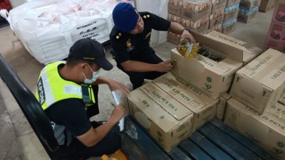 霹雳内贸局执法员在涉嫌囤积津贴食油的商店内，统计津贴食油数量，发现共囤积超过千包食油。