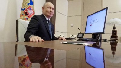俄罗斯总统普京进行线上投票后，特地向镜头微笑。电脑萤幕显示系统确认投票顺利完成。（图取自法新社/俄罗斯卫星通讯社）