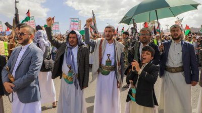 周五在也门“青年运动”控制的首都萨那，民众游行时举起枪和巴勒斯坦国旗，声援在加沙的巴勒斯坦人。（图取自法新社）