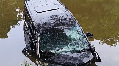 一辆丰田 Alphard休旅车失控坠入路旁深谷的湖内，司机受困车内，幸及时被消拯人员救出。（柔消拯局提供）