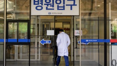 一名医护人员周五走进韩国首都首尔市的一家医院。（图取自法新社）