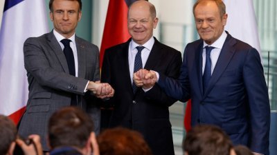 法国总统马克龙（左起）、德国总理肖尔茨和波兰总理图斯克，周五在柏林总理府举行的新闻发布会上携手，展现团结一致。（图取自法新社）