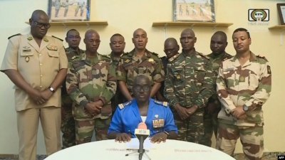 去年7月26日，尼日尔军政府发言人阿布德拉马内（中）在尼日尔国家电视台宣读了政变声明。（法新社档案照）