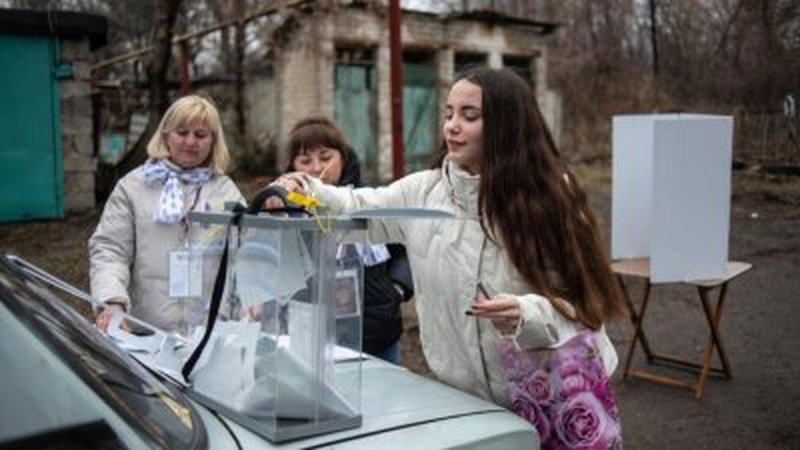 在俄罗斯控制的顿涅茨克举行的俄罗斯总统选举，一名妇女在周四的提前投票中，于移动投票箱投票。（图取自法新社）