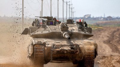 从以色列南部与加沙地带边境拍摄的照片显示，以色列陆军主战坦克周二沿著与巴勒斯坦领土接壤的边境行驶。（图取自法新社）