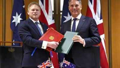 英国国防部长沙普斯（左）和澳洲国防部长马勒斯，周四在堪培拉国会大厦签署一项新的国防协议。（图取自法新社）