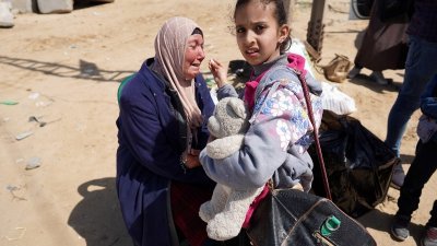 周四在加沙市中心，一名逃离希法医院及其周边地区的妇女，坐在自己的家当上伤心痛哭起来。（图取自法新社）