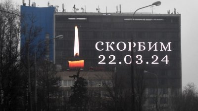 俄罗斯一栋建筑的广告屏幕显示点燃的蜡烛图像和“（我们）哀悼”字眼，悼念莫斯科音乐厅枪击事件的受害者。（图取自法新社）