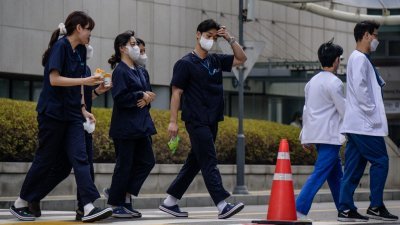 韩国医生抗议增收医科生的工潮持续逾一个月。医学院教授周一按计划集体提交辞职信，声援医学界行动。图为首尔一家医院外的医护人员。（图取自法新社）