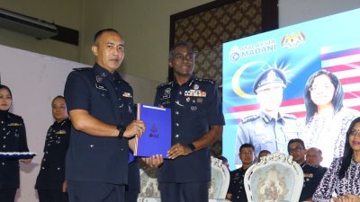 古玛（右）颁发奖状给表现卓越的警官。