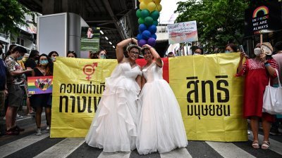 2022年6月5日，一对穿著婚纱的同性伴侣在曼谷参加 LGBTQIA+ 群体的骄傲游行。（图取自法新社档案照）