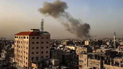 以色列与哈马斯之间持续冲突，以军在周三轰炸加沙地带南部拉法，建筑物上空冒出滚滚浓烟。（图取自法新社）