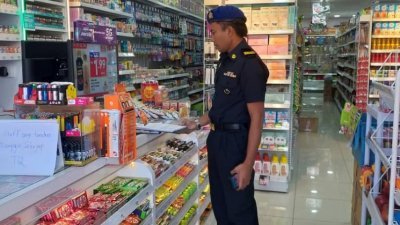 江沙一间新开张的超市因没有申请促销准证及统制品零售执照，遭到内贸局执法人员对付。（图由内贸局提供）