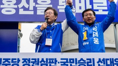 韩国最大在野共同民主党党首李在明（左）上周四在首尔，为该党推出的候选人拉票。（图取自法新社）