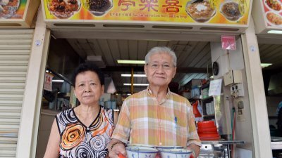 王明龙（右）与妻子杨凤英经营的摊位，多年来坚持不涨价，每一碗甜品只卖1新元。