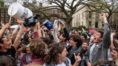 布朗大学宣布与反以挺巴的示威学生达成协议，同意研究如何自支持以色列的企业撤资，是第一所与示威学生达成撤资的藤校。图为学生在校园地上书写“撤资在即”字样。学生周二庆祝并拆除他们的营地。（图取自法新社）