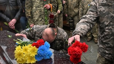 乌克兰军医拉夫罗夫斯基的葬礼4月24日在基辅独立广场举行葬礼，亲属和战友们在他的棺材旁向他致敬。（图取自法新社）