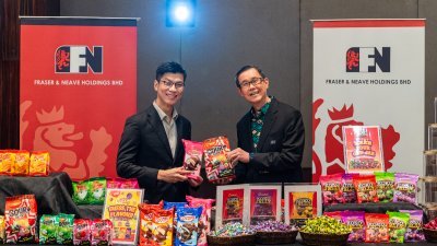 星狮控股首席财务员张焱垚（左）及首席执行员林友和在出席业绩汇报会后向媒体展示可可世界产品。