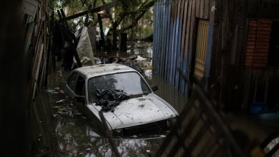 巴西南里奥格兰德州阿雷格里港遭遇洪灾，当地时间周五在萨兰迪社区可见房屋和汽车泡在水中。（图取自法新社）
