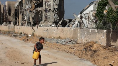 联合国世界粮食计划署警告，加沙地带北部地区已出现全面饥荒，呼吁以巴战争尽速实现停火。图为一名巴勒斯坦男孩在加沙北部吃力地提著水罐。（图取自法新社）