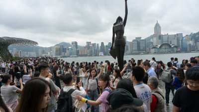 5月1日是中国“五一”假期的首天，众多旅客到香港尖沙咀游览。图为众多游客在尖沙咀海旁游玩。（图取自中新社）