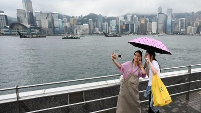 中国“五一”黄金周假期期间，来自中国的游客在香港尖沙咀海滨参观。（图取自法新社）