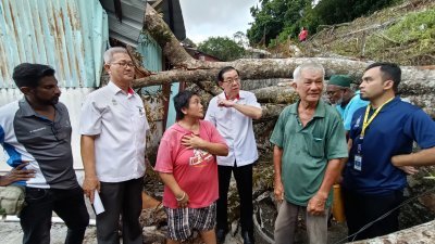 林冠英（左4）今日慰问遭老树倒塌撞毁屋顶的张普民夫妇。