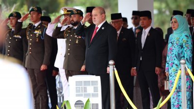 国家元首苏丹依布拉欣陛下（前排右）在启程前接受马来军队第一营的皇家敬礼。（柔佛王室媒体办公室提供）
