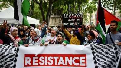 5月1日在法国东南部马赛，亲巴勒斯坦抗议者在“五一”集会上举著写著“反犹太复国主义、反殖民主义抵抗”的横幅。（图取自法新社）