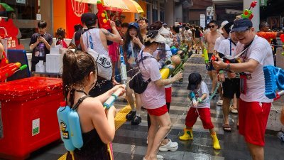 4月13日在泰国曼谷，当地民众和各国游客在大街小巷欢庆泼水节。（图取自中新社）