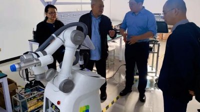 吴添泉与夫人潘斯里何淑娟（左2与1）聆听李博浧（右2）讲解有关机器人科技与操作情况，右为肖岭。