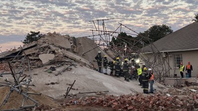 南非乔治市一座建筑在周一倒塌，据信还有数十人受困瓦砾堆中，救援人员周二仍在现场进行搜救。（图取自法新社）