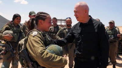 以色列国防部长加兰特周二在以色列南部靠近拉法，与加沙地带接壤的边境阵地上探望士兵。（图取自法新社）