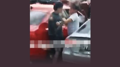 两名男子站在一辆红色轿车和灰色轿车的中间，一来一往互相挥拳。 （影片截图：面子书/SG Road Vigilante-SGRV）