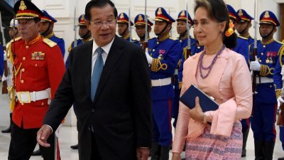 2019年4月30日，缅甸国务资政昂山淑姬（右）和柬埔寨首相洪森在金边和平宫走过仪仗队。（图取自法新社档案照）
