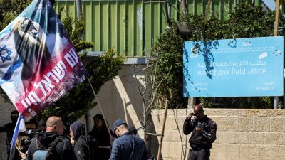 以色列右翼抗议者今年3月20日举著旗帜和横幅，聚集在耶路撒冷的联合国近东救济工程处西岸外地办事处外示威。（图取自法新社）